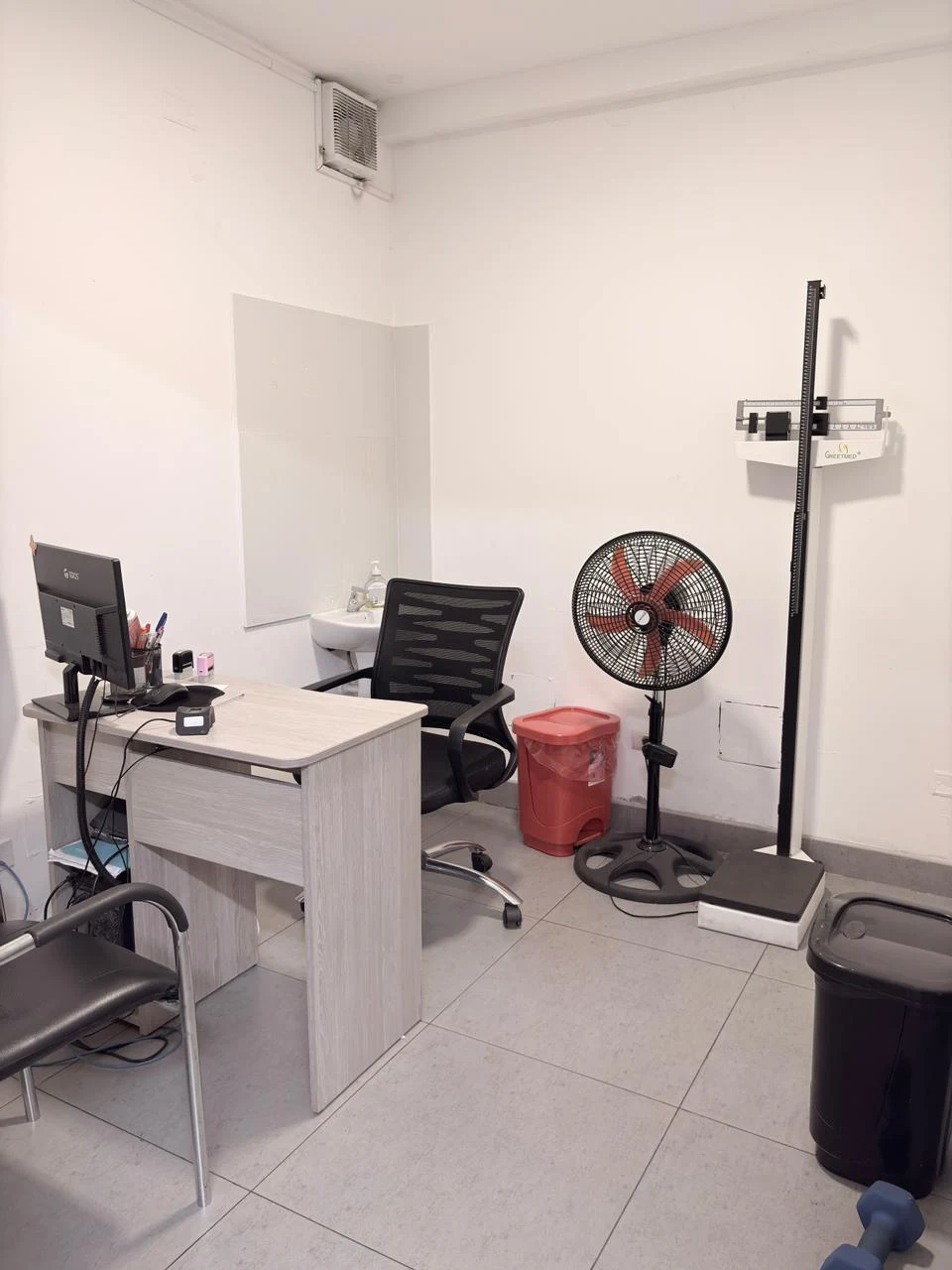Consultorio médico de triaje equipado con balanza y tallímetro.